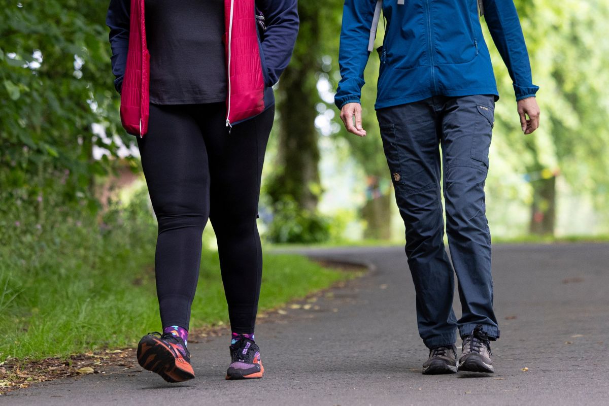 A close up of two women walking side by side along a path.